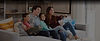 Family sitting on couch watching television